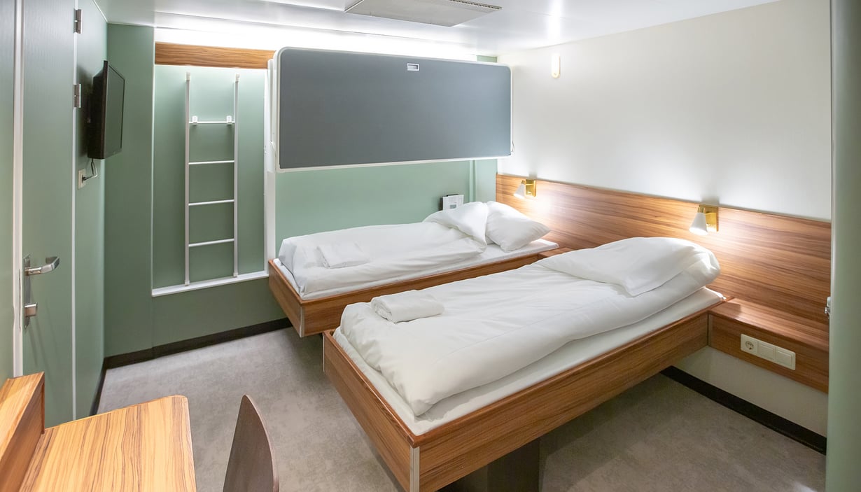 Cabin with bunk beds and a bedside table.