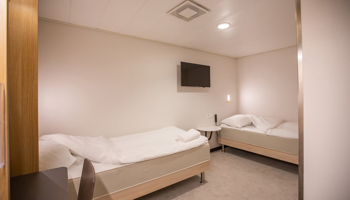 Accessible cabin with two single beds and a round table.