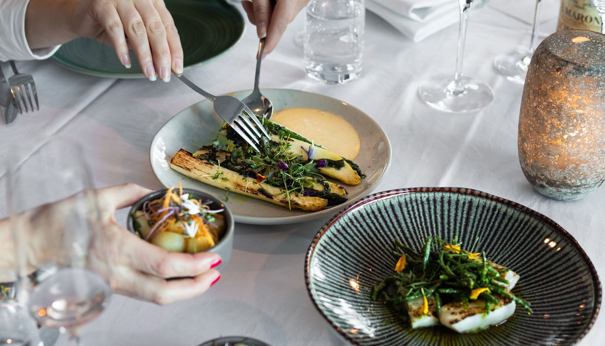 Hands serving themselves from shared dishes