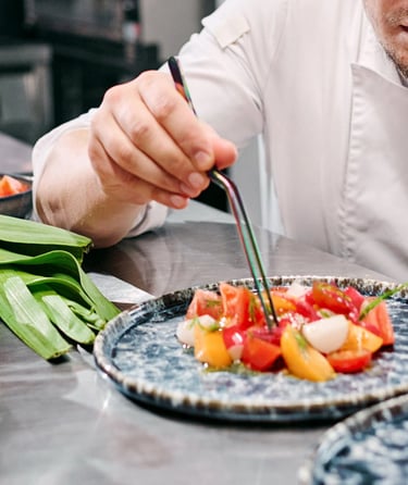 A chef placing the food on the plates