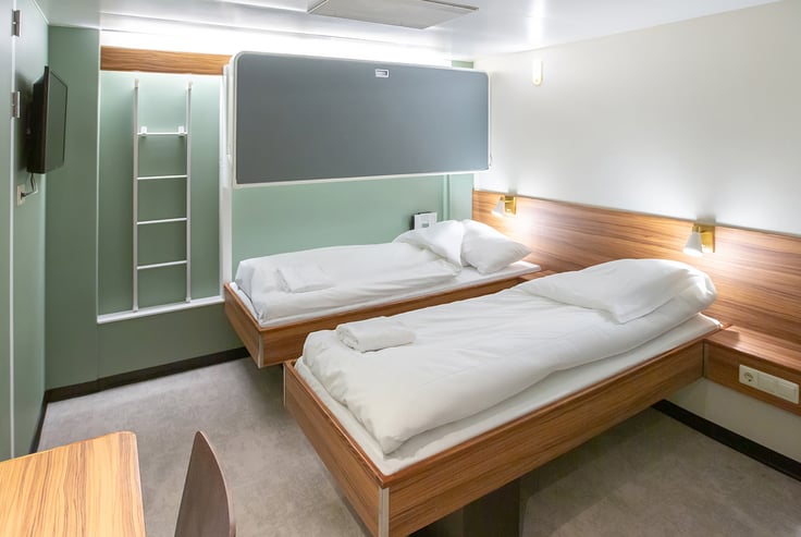 Cabin with bunk beds and a bedside table.