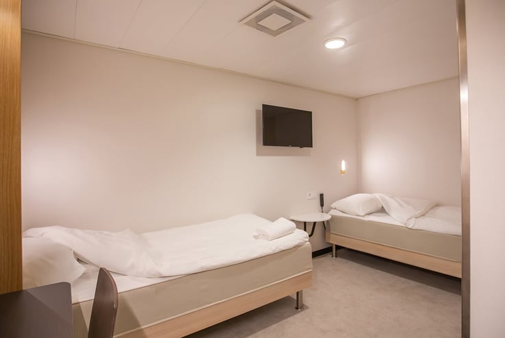 Accessible cabin with two single beds and a round table.