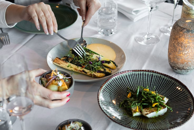 Hands serving themselves from shared dishes