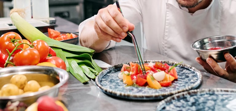 A chef placing the food on the plates
