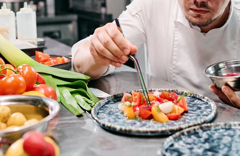 A chef placing the food on the plates